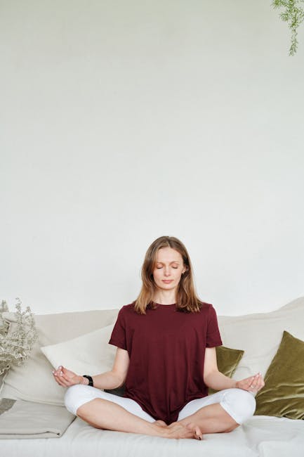 Serene woman with closed eyes practicing pranayama breathing technique indoors.